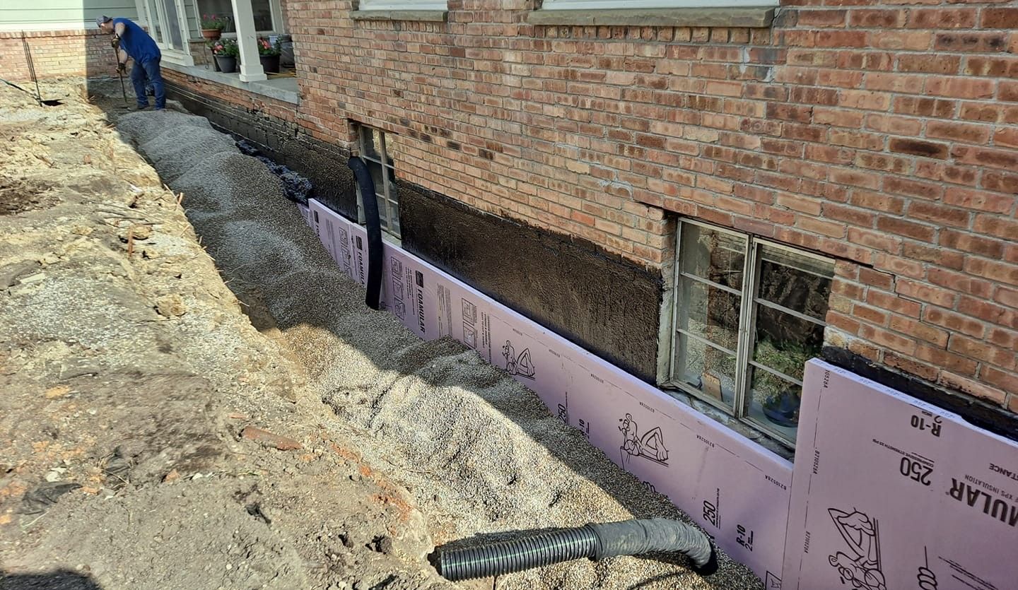 Excavating next to a foundation to expose the basement wall. Waterproofing is installed. Backfill with peastone and sand